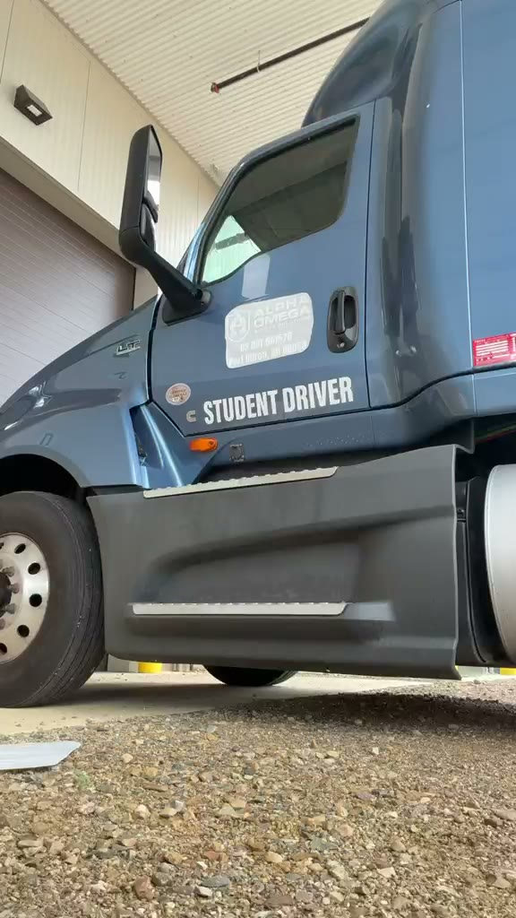 Clip: a student inspecting the door of a CDL training tractor marked STUDENT DRIVER