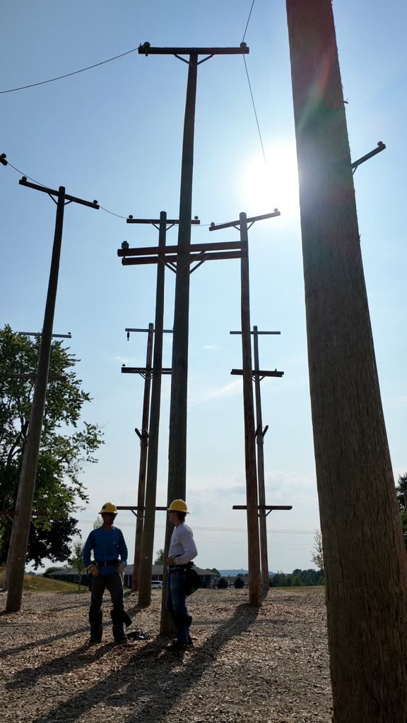 Utility poles in the outdoor training yard backlit by the sun
