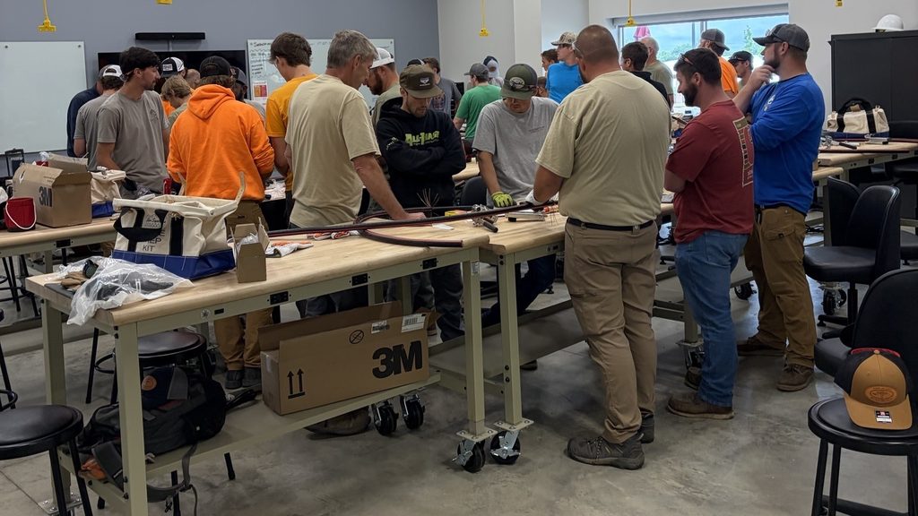 Utility crews working prepared medium-voltage cable and termination kits along a line of rolling workbenches