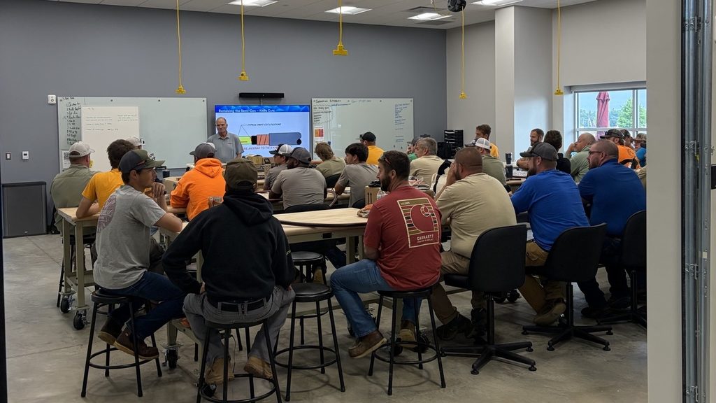 Instructor presenting a cable-preparation slide to a full room of seated utility crews at the Applied Technology Center