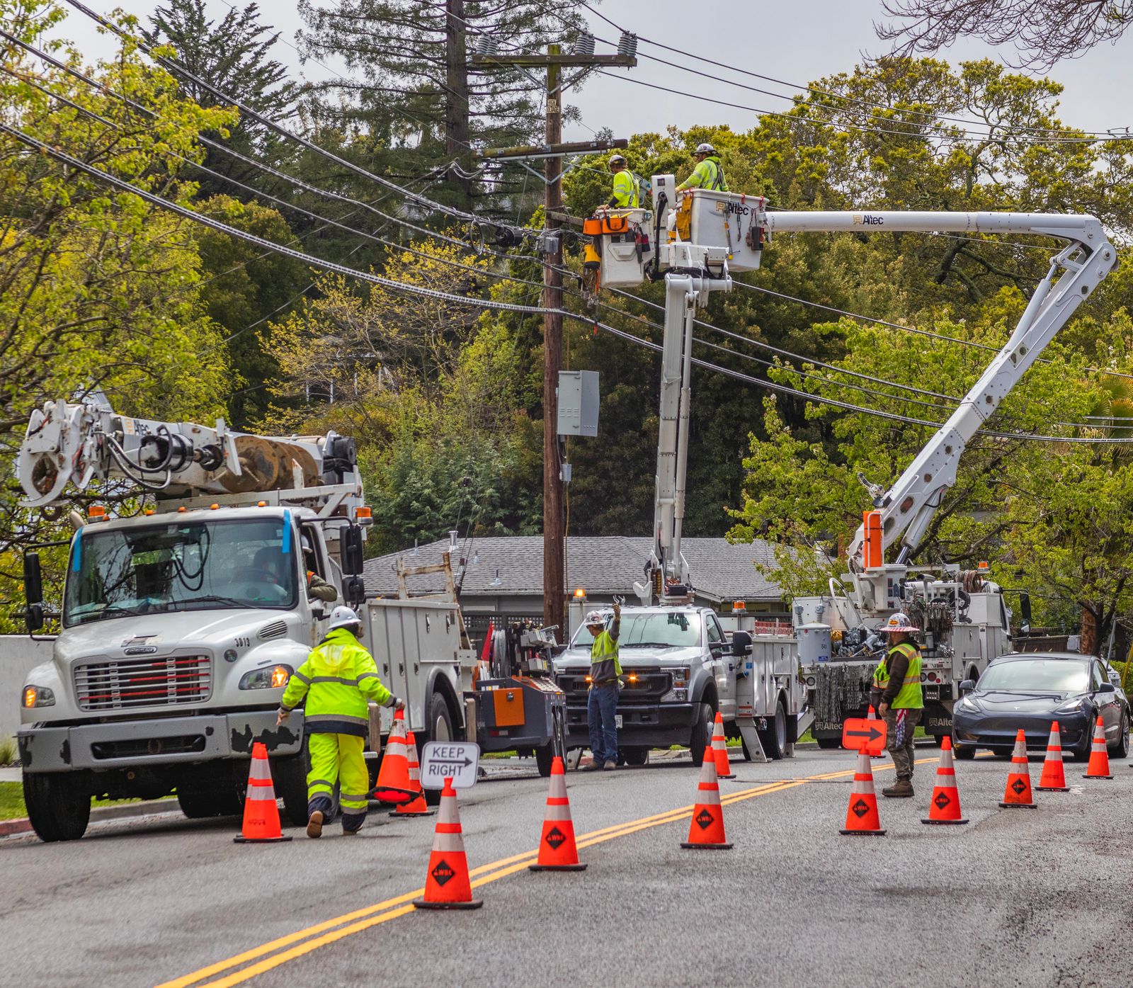 Alpha Omega line crew working from bucket trucks on a residential street