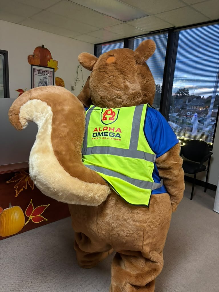 The same mascot from behind, showing the Alpha Omega Safety Solutions logo across the back of the hi-vis vest